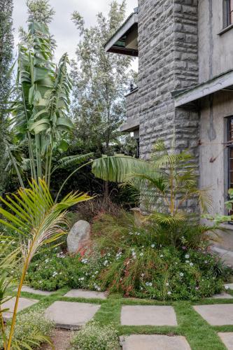 a garden in front of a building with plants at Enkarsis Resort Villa in Kitengela 