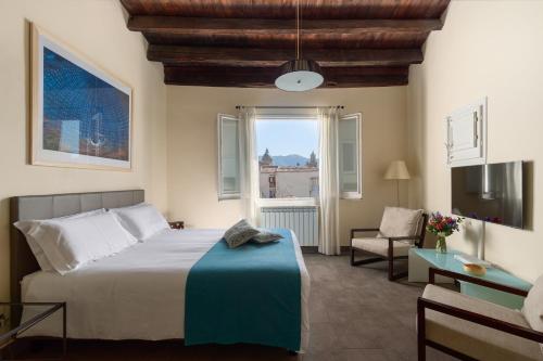 a bedroom with a bed and a chair and a window at Palazzo Sant'Agostino in Palermo