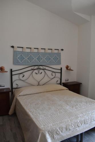 a bedroom with a large bed with a white bedspread at Giardini Malaspina in Bosa