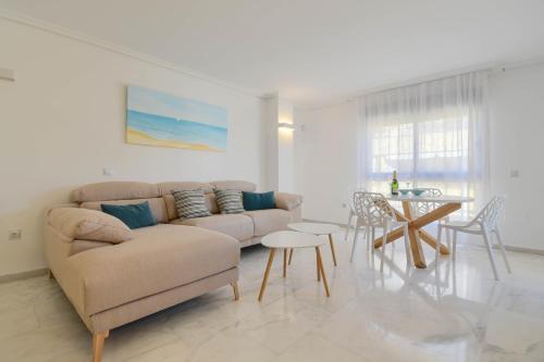 ein Wohnzimmer mit einem Sofa und einem Tisch in der Unterkunft Apartamento en Moraira Moramar in Moraira