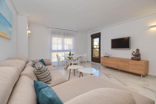 ein Wohnzimmer mit einem Sofa und einem TV in der Unterkunft Apartamento en Moraira Moramar in Moraira