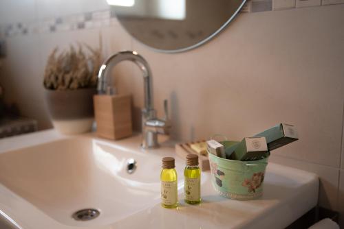 a bathroom sink with two bottles of essential oils on it at Casale Monte Valestra in Bebbio