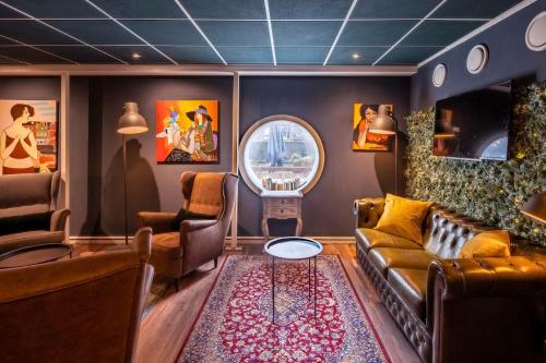 
a living room filled with furniture and a mirror at H2OTEL Rotterdam in Rotterdam
