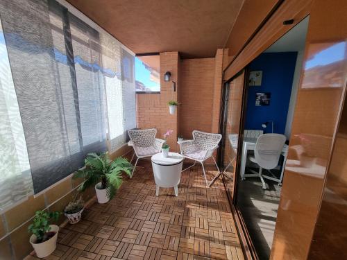 Habitación con balcón con sillas y bañera. en Apartamento Las Rozas Village, en Las Rozas de Madrid