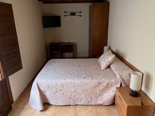 a bedroom with a bed with a night stand and a lamp at LA CASONA DE PALMIRA in Caín