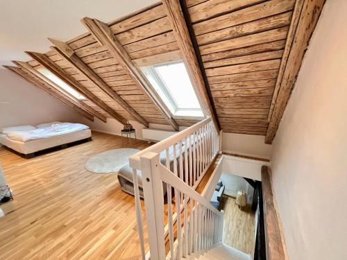 a attic room with a bed and a staircase at Chalet & Apart Fichtelberger Blick in Kurort Oberwiesenthal