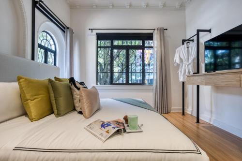 a bedroom with a bed with a book on it at UTOPIC Campos Elíseos by ULIV in Mexico City