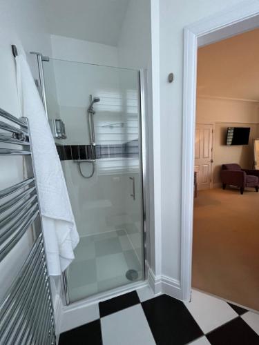 a shower with a glass door in a bathroom at Between the Bays exclusively for Adults in Llandudno