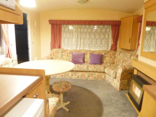 a living room with a couch and a table at Beachside, Family-friendly, WiFi, 6 berth Caravan 12 in Ingoldmells