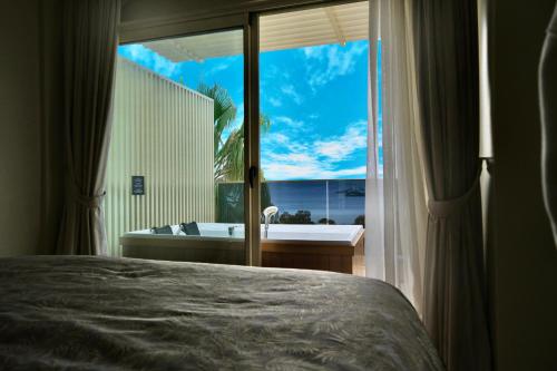 een slaapkamer met uitzicht op een bad en een raam bij Roas Hotel in Bitez