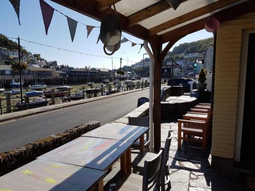 a row of tables and benches on the side of a building at The Harbour Moon in Looe