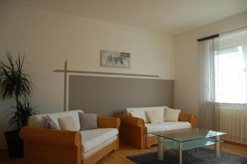 a living room with two chairs and a glass table at Ferienwohnung Maks und Kris in St. Andrä am Zicksee