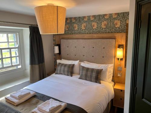 - une chambre avec un grand lit blanc et 2 oreillers dans l'établissement Queens Head Inn, Tirril, à Penrith