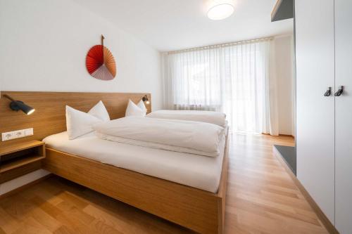 um quarto com uma cama grande e lençóis brancos em das Blum em Hagnau