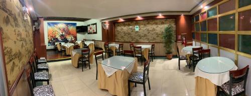 a restaurant with tables and chairs in a room at Hotel Oro Inn in Lima