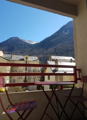 un balcon avec un banc et une vue sur une ville dans l'établissement Studio Cauterets Résidence le Lys, à Cauterets