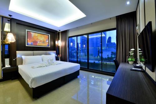 een slaapkamer met een groot wit bed en een groot raam bij The Prestige Nana in Bangkok