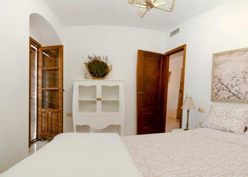 a white bedroom with a bed and a window at Penthouse in the Historic District in Córdoba