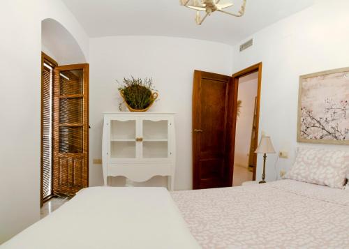biała sypialnia z łóżkiem i oknem w obiekcie Central Historic Penthouse w Kordobie