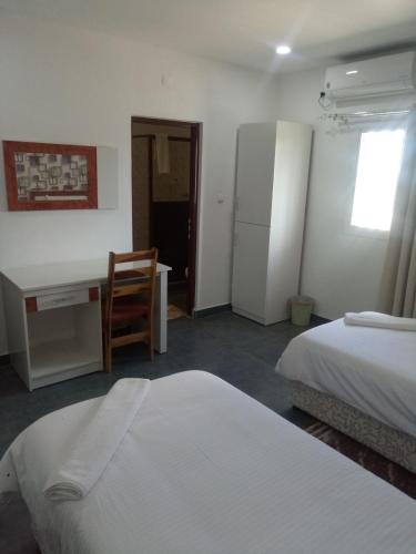 a bedroom with two beds and a desk and a desk at RESIDENCIAL AFRICA,LDA-NAMPULA in Nampula