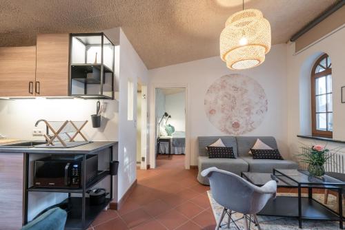 a kitchen and living room with a couch and a table at Schloss-Castel Pienzenau - Guestrooms & Apartments - B&B-Hotel & Restaurant in Merano