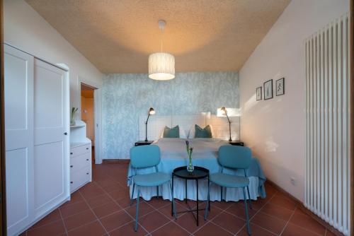 a bedroom with a bed and two blue chairs at Schloss-Castel Pienzenau - Guestrooms & Apartments - B&B-Hotel & Restaurant in Merano