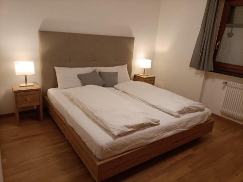 ein Schlafzimmer mit einem großen Bett mit zwei Lampen in der Unterkunft CasaViva - Grazioso bilocale all’Alpe di Siusi in Kastelruth