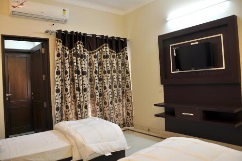 a living room with a tv and a window at Mohini Home Stay in Agra