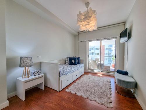 a white bedroom with a bed and a window at Foz Palace Spa Luxury Residence in Portimão