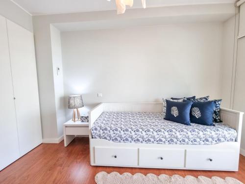 a bedroom with a white bed with blue pillows at Foz Palace Spa Luxury Residence in Portimão