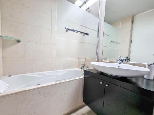 a bathroom with a white tub and a sink at Foz Palace Spa Luxury Residence in Portimão