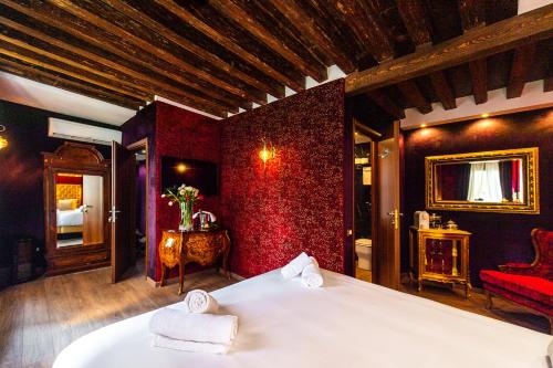 ein Schlafzimmer mit einem Bett und einer roten Wand in der Unterkunft Ca' Maria Callas in Venedig