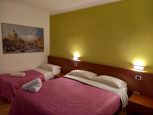羅馬的住宿－La Casa Dell'Arte srl，酒店客房设有两张床,墙上挂有绘画作品