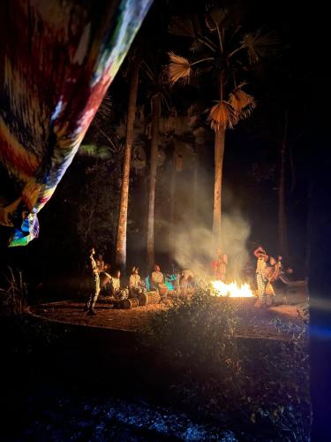 a group of people standing around a fire at night at Nemasu Eco-lodge in Gunjur