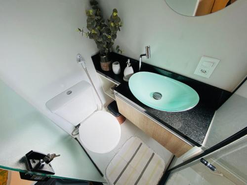 a bathroom with a white toilet and a sink at Minicasa Brasileira in Sorocaba