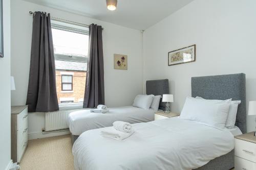 two beds in a room with a window at Enfield House in Coventry