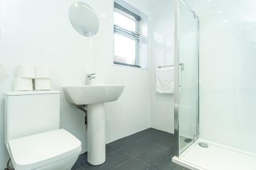 考文垂的住宿－Enfield House，浴室配有卫生间、盥洗盆和淋浴。
