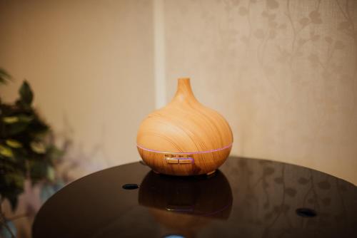 a wooden vase sitting on top of a table at Spa Lux Apartmani in Novi Sad