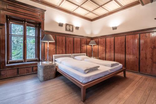 a bedroom with a bed in a room with wooden walls at Schloss-Castel Pienzenau - Guestrooms & Apartments - B&B-Hotel & Restaurant in Merano