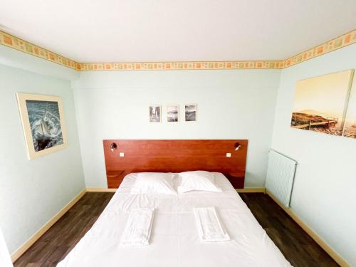 a bedroom with a large white bed in it at Hotel les Alignements in Carnac