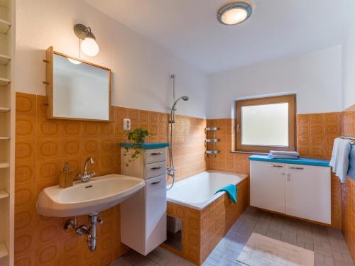 bagno con lavandino e vasca di Apartment Rabl a Kirchbichl