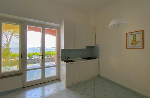 a white kitchen with a view of the ocean at Residence Intur in Marciana Marina