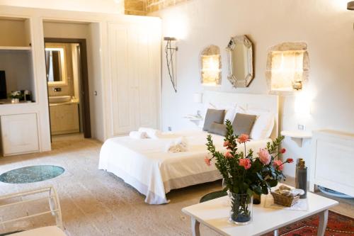 a bedroom with a bed and a table with flowers at Tenuta Monacelli Lecce in Lecce