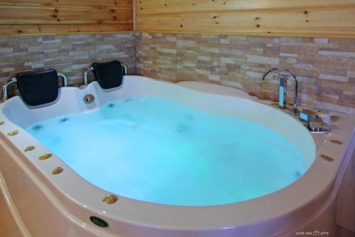 a large bath tub with a blue light in a room at בקתות מול השקיעה in Wadi Keren