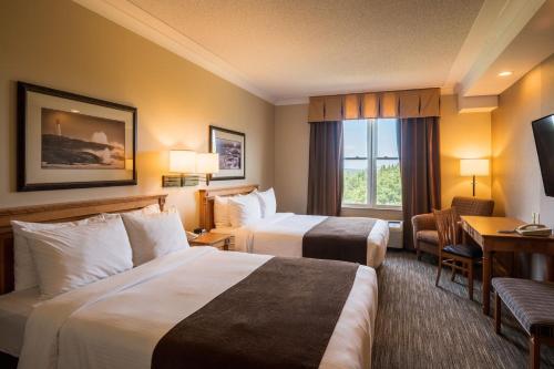 a hotel room with two beds and a desk at Future Inns Halifax Hotel & Conference Centre in Halifax