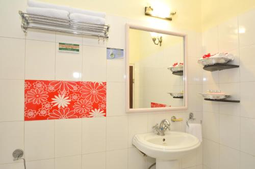 a white bathroom with a sink and a mirror at Mahal Khandela - A Heritage Hotel and Spa in Jaipur