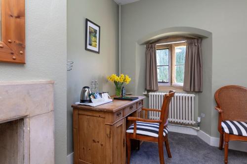 a room with a desk and chairs and a window at Charney Manor in Kingston Bagpuze