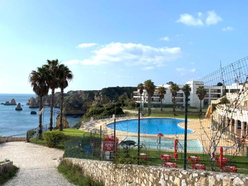 a view of a swimming pool next to the ocean at Apartamento na praia dona Ana - Iberlagos in Lagos