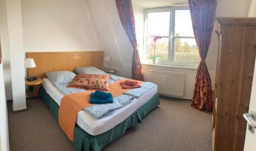 a bedroom with a bed and a window at Sterntaler (Landhaus Immenbarg) in Rostock