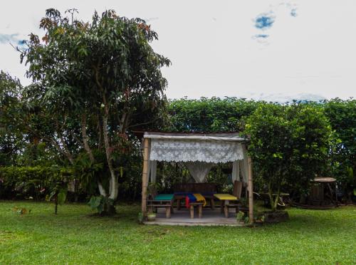 a gazebo with a table and chairs in a yard at Hotel Campestre Sueño del Abuelo in Pereira